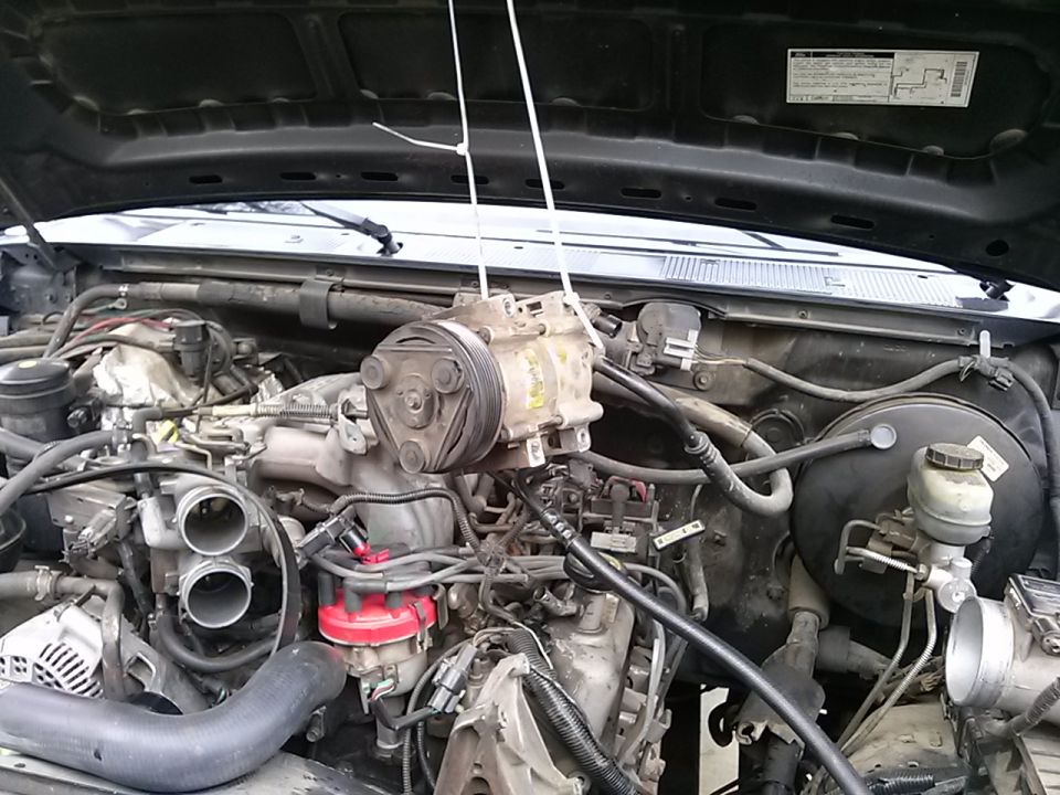 Engine bay of a 1996 Ford Bronco with AC compressor removed