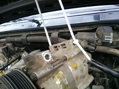 1996 Ford Bronco - Close-up of an engine part being held in place with zip ties.