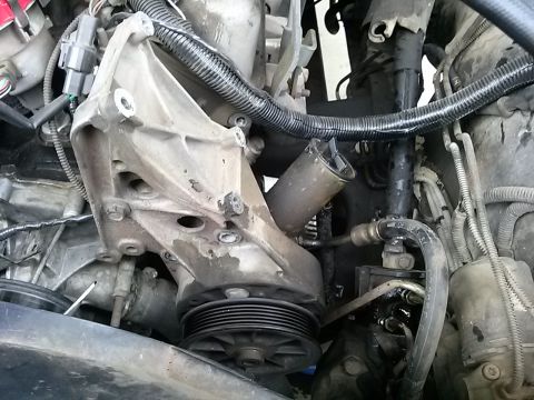 1996 Ford Bronco - Close-up view of a vehicle's engine pump assembly, showing mechanical components and associated hoses.