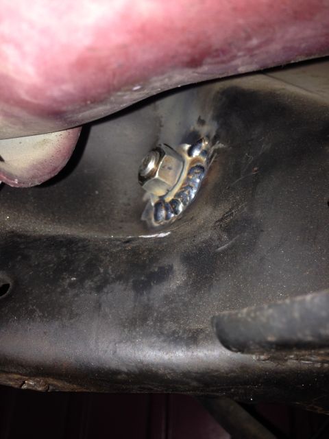 1992 Ford Crown Victoria - A close-up view of a nut that has been welded onto a vehicle's frame, indicating a repair or modification.