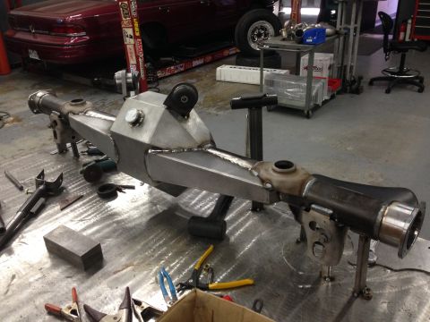 1992 Ford Crown Victoria - Custom rear axle assembly in a workshop setting, surrounded by tools and fabrication equipment.