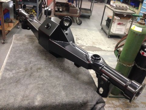 1992 Ford Crown Victoria - Custom rear axle housing sits on a blanket in a fabrication shop with welding equipment nearby.
