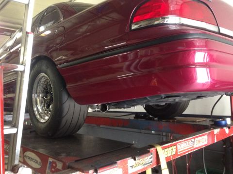 1992 Ford Crown Victoria - Rear view of a 1992 Ford Crown Victoria on a lift, showing its quarter panel and a drag radial tire.