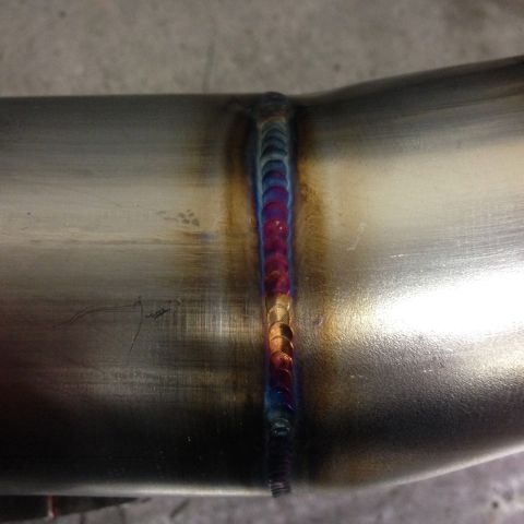 1992 Ford Crown Victoria - Welded metal pipe with colorful heat tinting along the seam.