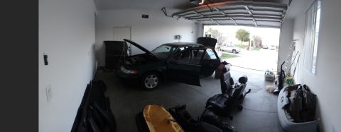 1993 Ford Taurus - 1993 Ford Taurus in a garage, with its hood and doors open, and various interior parts laid out.