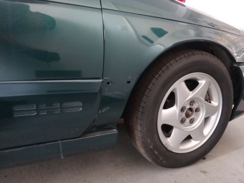 1993 Ford Taurus - Close-up of the fender and wheel of a green 1993 Ford Taurus SHO.