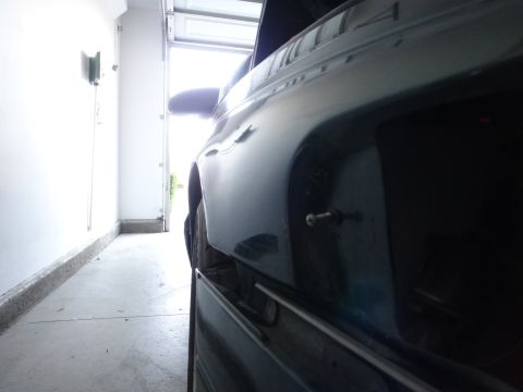 1993 Ford Taurus - A dark sedan is parked inside a garage with the door open, showing its side profile.