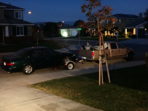 1993 Ford Taurus - A green sedan and a gold pickup truck are parked in a driveway at dusk.