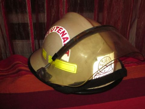 1991 Ford Crown Victoria - A tan firefighter helmet with reflective markings and "LIEUTENANT" text is displayed against a striped background.