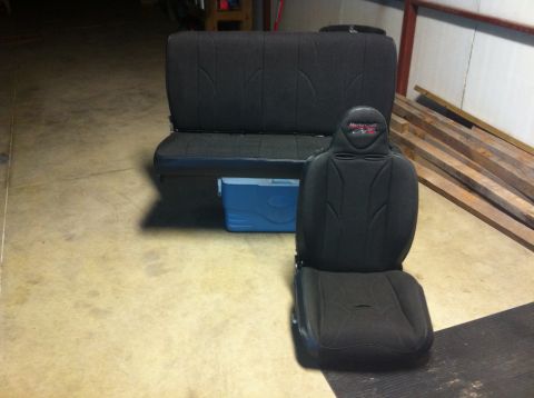 1982 Ford Bronco - Two black car seats and a blue cooler are displayed on a concrete floor.