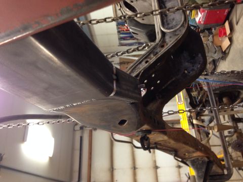1993 Ford Bronco - Close-up view of vehicle frame and suspension components undergoing work in a garage setting.
