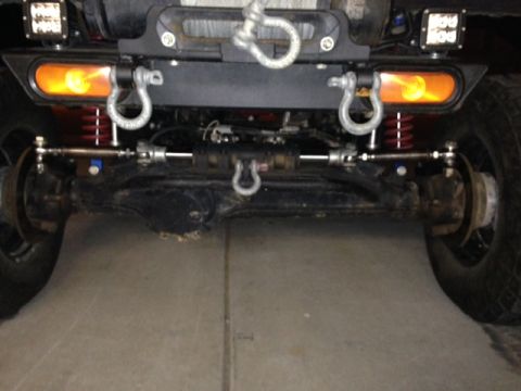 1987 Suzuki Samurai - Close-up view of a vehicle's front axle, steering components, and winch.