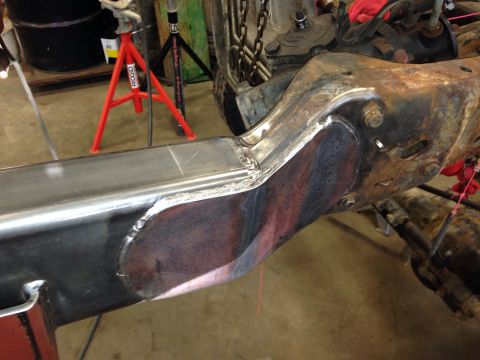 1993 Ford Bronco - Close-up of a vehicle's frame undergoing repair with new metal welded into place.