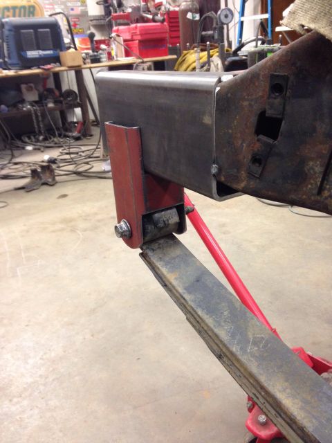 1993 Ford Bronco - Close-up of a leaf spring and frame modification in a workshop setting.