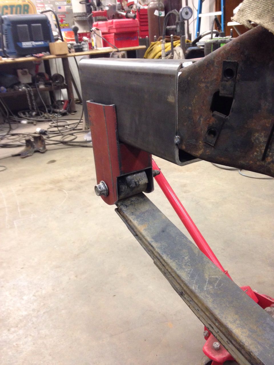 Leaf spring attached to a modified frame section with red bracket