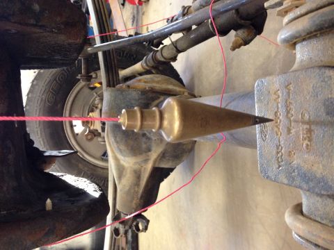 1993 Ford Bronco - A plumb bob is used to check the alignment of the vehicle's suspension system.