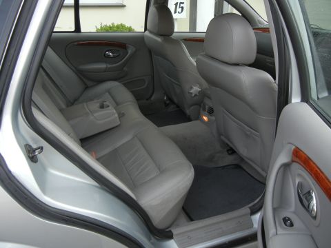 1999 Ford Fairlane - The interior of a car shows gray leather seats and wood trim accents on the doors.