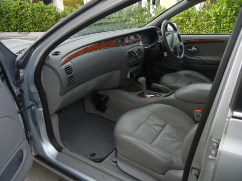 1999 Ford Fairlane - Interior view of a 1999 Ford Fairlane, highlighting its grey leather seats and dashboard details.