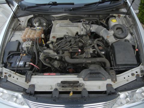1999 Ford Fairlane - The engine bay of a silver vehicle, a V8 engine and a prominent Supermotors.net watermark.