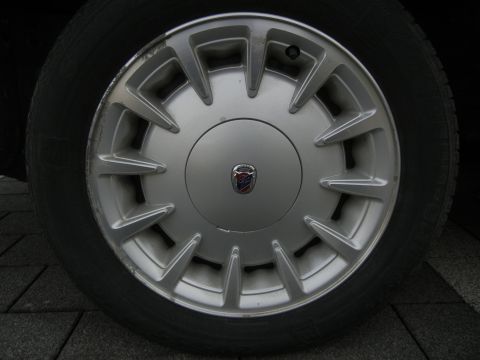 1999 Ford Fairlane - Silver alloy wheel with a central emblem, likely from a car.