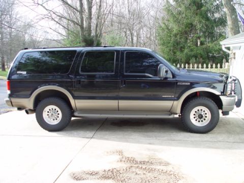 2003 Ford Excursion - Side view of a Ford Excursion SUV with tinted windows and two-tone paint.
