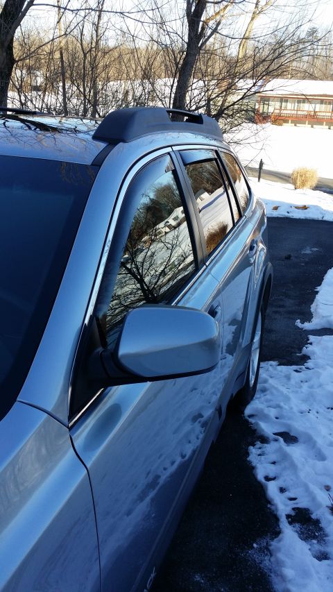 2014 Subaru Outback - Silver SUV side view with roof rack and window visors, parked in snow.
