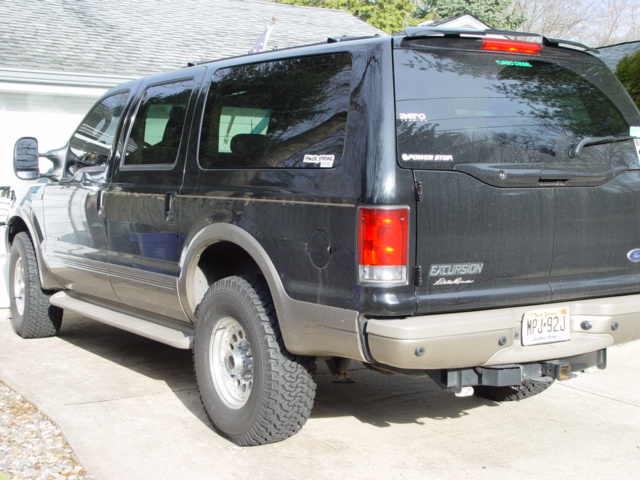 Black Ford Excursion SUV, rear three-quarter view in driveway