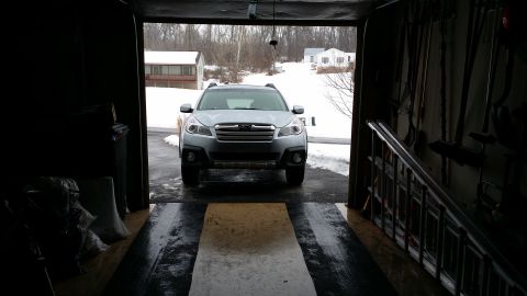 2014 Subaru Outback - Front view of a silver 2014 Subaru Outback parked inside a garage during winter.