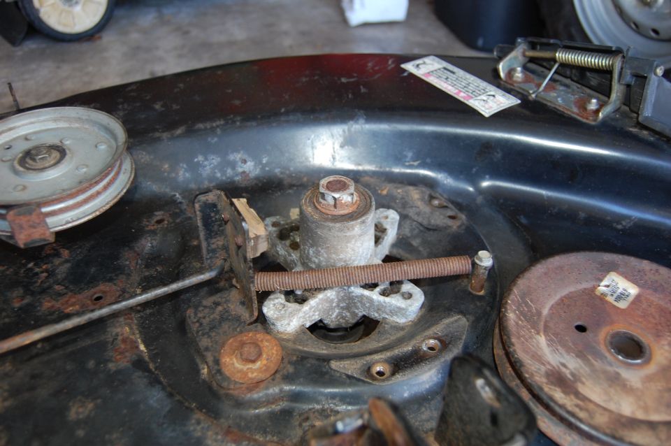 Lawn mower deck spindle assembly with pulley and rusty screw