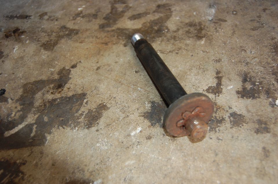 Bolt with a rusty star-shaped washer on a concrete surface
