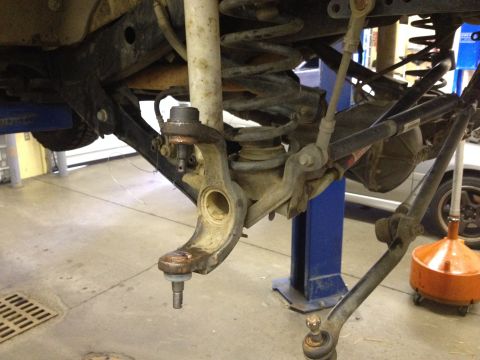 2005 Jeep Wrangler - The image shows a close-up of a vehicle's suspension system, focusing on a ball joint assembly that has been disconnected.