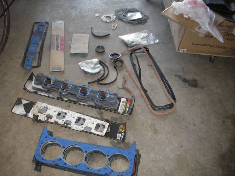 1972 Ford Ranchero - Various engine components, including gaskets and seals, are spread across a concrete surface.