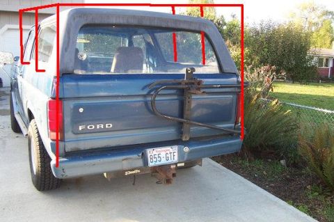 1980 Ford Bronco - Rear view of a blue Ford Bronco parked on a driveway with the removable hardtop and rear glass outlined in hand-drawn red boxes marking the…