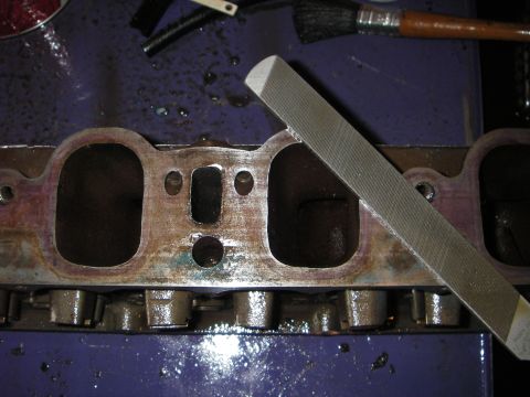 1972 Ford Ranchero - Working on an engine cylinder head with a file, with various tools in the background.