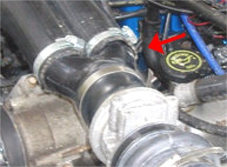 1990 Ford Bronco - Close-up of engine plumbing, with a red arrow indicating the oil cap.