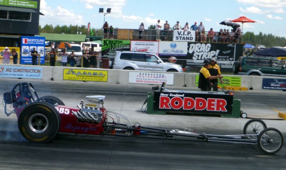 Red dragster with number 85 on side at a drag strip