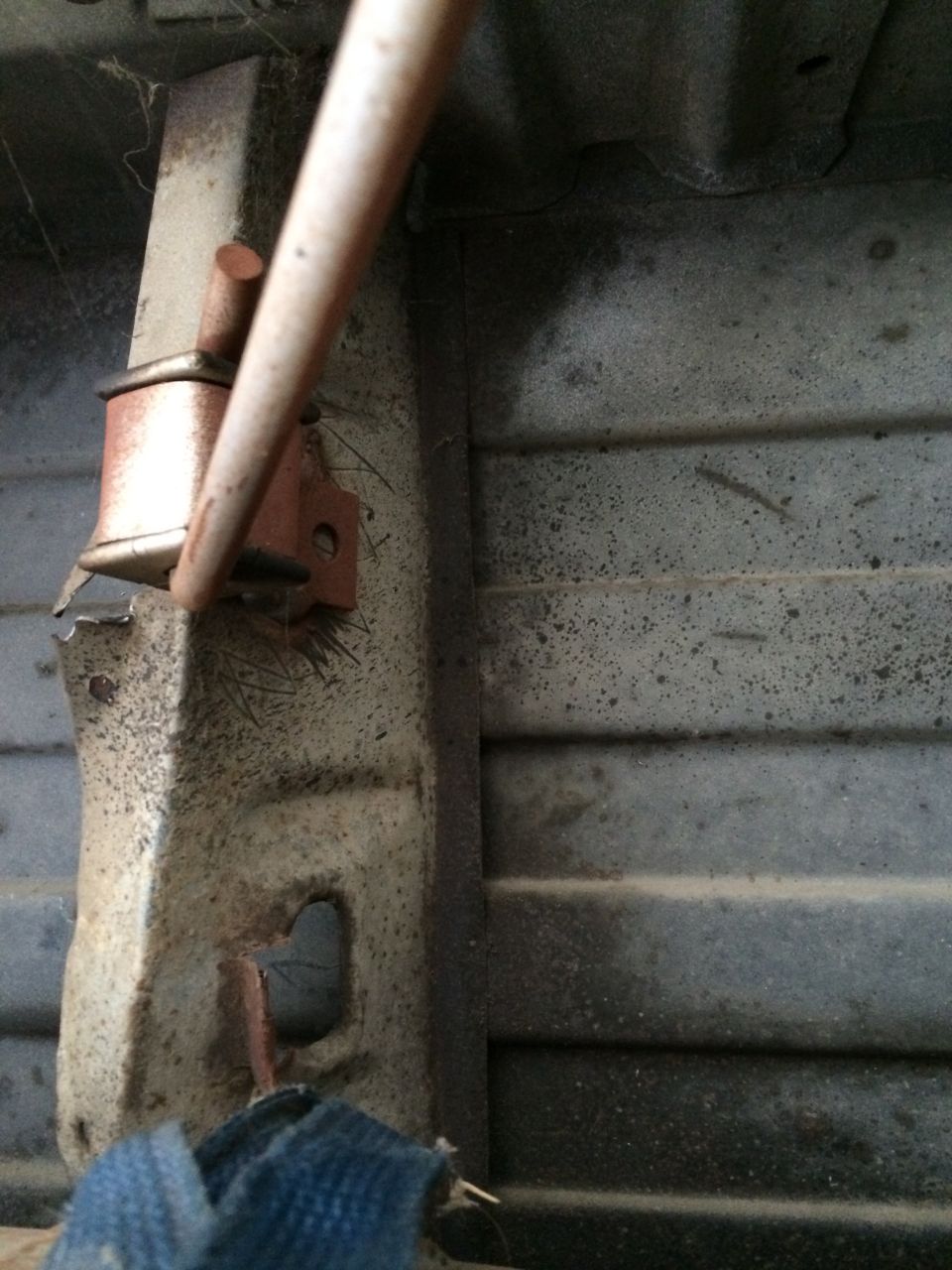 Underbody part with broken strap and metal rod