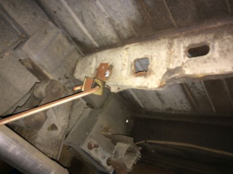 1964 Ford Ranchero - The fuel tank strap appears to have broken, revealing the undercarriage of the vehicle.