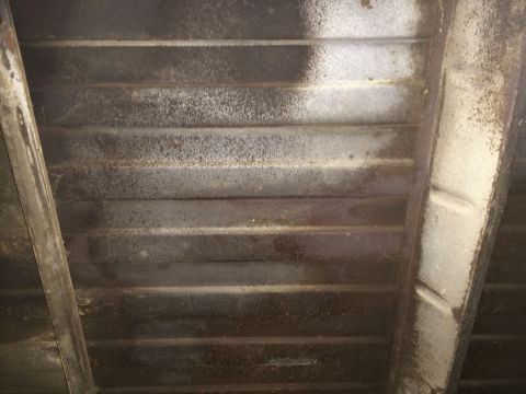 1964 Ford Ranchero - Underside view of a truck bed, showing ribbed metal construction and some paint overspray.