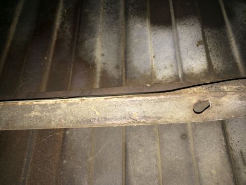 1964 Ford Ranchero - The underside of a truck bed shows ribbed metal and a rusty support beam, indicating wear and tear.