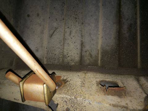1964 Ford Ranchero - A rusted tank strap bracket shows signs of wear and tear, with a broken strap attached.