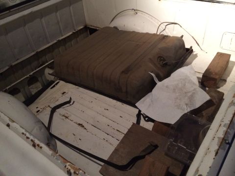 1964 Ford Ranchero - A large, rusty fuel tank is stored in the bed of a white pickup truck.