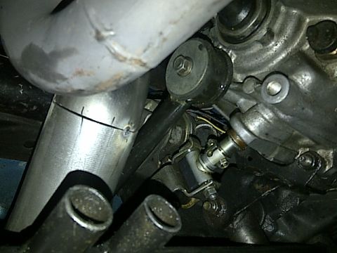 1995 Ford Probe - Close-up view of exhaust pipe connections and engine parts, with visible text from Supermotors.net.