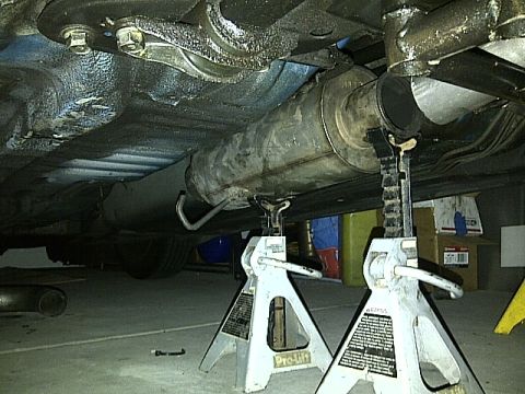 1995 Ford Probe - Car's exhaust system is elevated on jack stands for maintenance or repair.