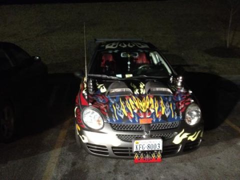 1979 Ford Bronco - A modified Dodge Neon SRT-4 is parked at night, showing off its custom flame graphics and aftermarket hood scoops.