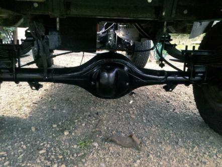 1982 Ford Bronco - Close-up view of the rear differential and suspension system of a vehicle, with a Supermotors.net watermark.