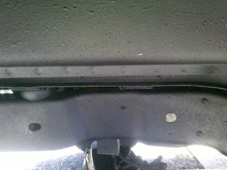 1982 Ford Bronco - Close-up view of a vehicle's undercarriage, revealing frame and suspension parts.