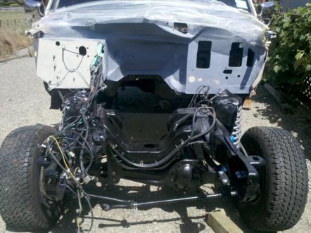 1982 Ford Bronco - The engine bay of a vehicle is shown with exposed wiring and suspension components, suggesting it is undergoing maintenance or restoration.