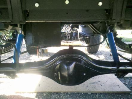1982 Ford Bronco - The underside of a vehicle shows the rear differential, suspension, and part of the drivetrain.