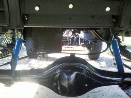1982 Ford Bronco - The underside of a vehicle is visible, focusing on the rear axle and suspension components.